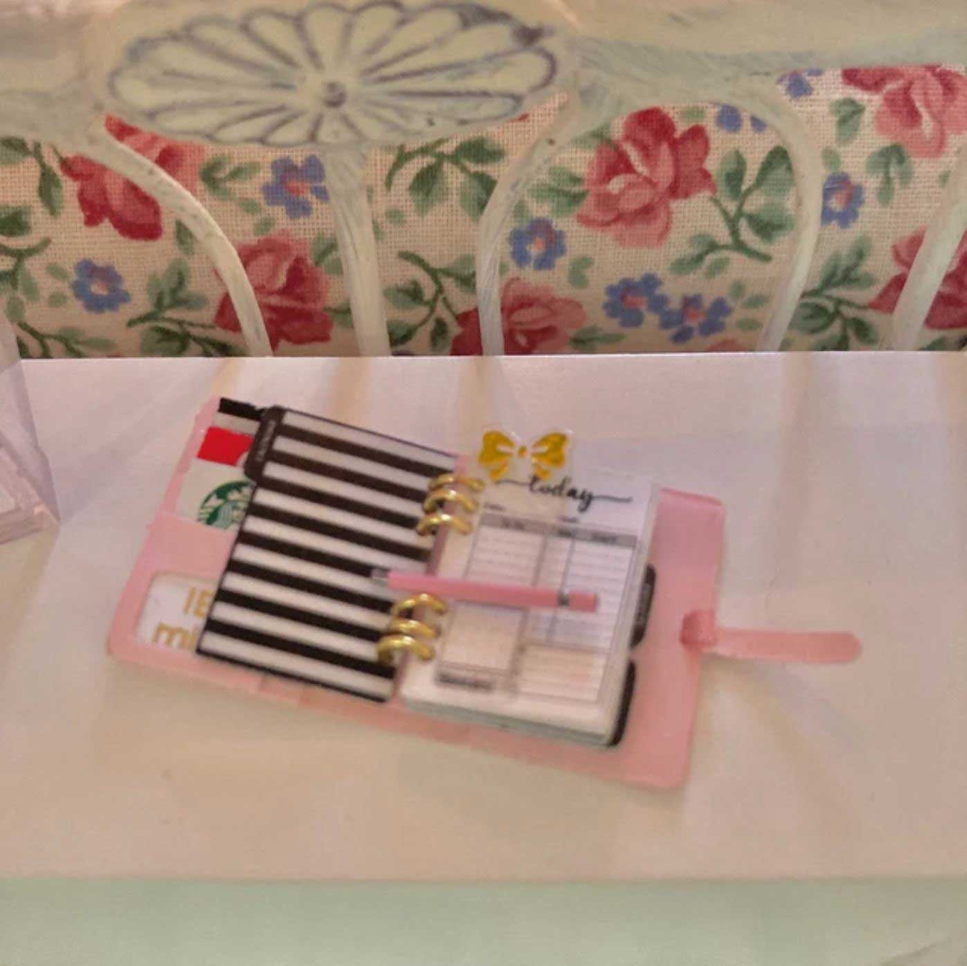 pink dollhouse miniature planner in on desk